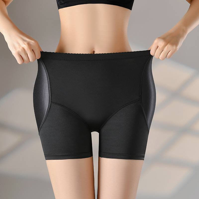A person wearing black hip enhancer pads, holding the waistband of the shorts.