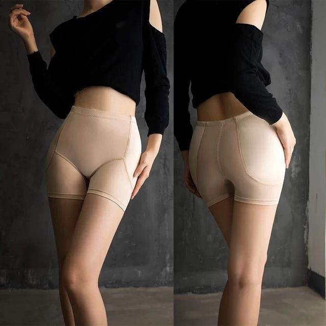 Model wearing a black off-shoulder top paired with skin-toned shaping shorts, showcasing a side and back view against a concrete backdrop.