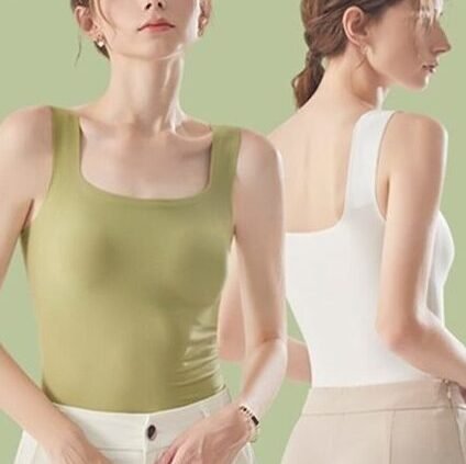 Two women standing back to back, one wearing a green tank top and the other in a white tank top, with a light green background.