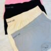 Four pairs of Munafie shorts in different colors: pink, black, beige, and grey, arranged in a row on a soft surface.