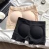 Two pairs of butt lifter shaper shorts in beige and black lying on a light surface.