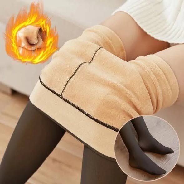 A pair of thermal stockings being worn with a close-up view of the legs. One leg is covered with a beige thermal fabric while the other shows black tights.