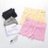 A display of Munafie shorts in various colors including pink, yellow, gray, white, and black, arranged neatly with a perfume bottle.